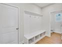 Bright mudroom with built-in bench, cubbies, coat hooks and a door leading to a well-lit bathroom at 5707 Tillman Way, Powder Springs, GA 30127