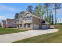 Spacious two-story home with a long driveway leading to a three-car garage, and a well-kept lawn at 318 Delta Dr, Mcdonough, GA 30253