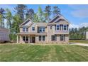 Beautiful two-story brick home with gray shutters, lush green lawn, and mature trees at 318 Delta Dr, Mcdonough, GA 30253