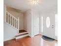 Bright foyer with hardwood floors, a white staircase, and a front door with decorative windows at 59 Pompas Ct, Dallas, GA 30157