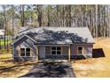 Inviting home with gray siding, stone foundation, and a cozy covered entry, nestled among tall trees at Tract1 Harmony Rd, Temple, GA 30179