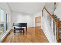 Living room featuring hardwood floors, large windows, and a grand piano at 1464 Oglethorpe Dr, Suwanee, GA 30024