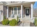 Brick front porch with white columns, stone flooring, and two chairs at 1868 Lakeview Bend Way, Buford, GA 30519