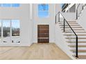 Bright foyer with hardwood floors, modern staircase, and a contemporary front door, creating an inviting entrance at 2753 Camp Branch Rd, Buford, GA 30519