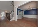 Living room with hardwood flooring and a staircase, complemented by wainscotting and blue accent wall at 54 Etham Pl, Douglasville, GA 30134