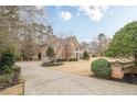 Brick home featuring an expansive driveway, manicured landscaping and a well-maintained lawn, enhancing its curb appeal at 5216 Old Mountain Ln, Powder Springs, GA 30127