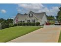 Brick house with a large front yard, lush landscaping, and a paved driveway with two cars parked at 1403 Shiloh Oak Dr, Loganville, GA 30052