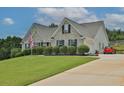 Brick house with a large front yard, lush landscaping, and a paved driveway with a red Smart car parked at 1403 Shiloh Oak Dr, Loganville, GA 30052