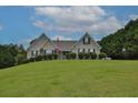 Brick house on a hillside with a large grassy yard and lush landscaping at 1403 Shiloh Oak Dr, Loganville, GA 30052