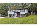 Gray sided house with red door and stone accents, on a grassy lot at 1906 Young Rd, Lithonia, GA 30058