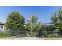 Gated community entrance with lush landscaping and an American flag waving in the breeze at 5200 Peachtree Rd # 3221, Chamblee, GA 30341