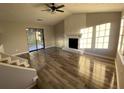 Bright living room featuring wood flooring, a cozy fireplace, and sliding glass doors to the backyard at 1126 Mainstreet Valley Dr, Stone Mountain, GA 30088