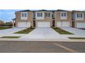 Tan brick townhomes with white accents, two-car garages, and a shared driveway at 317 Heavenly Hollow Pl, Mcdonough, GA 30253