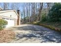 Long driveway leading to a spacious garage and a lush, wooded backyard at 2265 Pine Point Dr, Lawrenceville, GA 30043