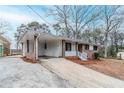 Single-story brick home with a carport and a white picket fence in a suburban neighborhood at 2600 Burkshire Rd, Ellenwood, GA 30294