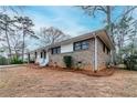 Angle shot of brick house with carport, white trim, and minimal landscaping on a blue-sky day at 2600 Burkshire Rd, Ellenwood, GA 30294