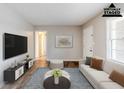 Virtually staged living room featuring modern decor, wood flooring, neutral walls and large television at 2600 Burkshire Rd, Ellenwood, GA 30294