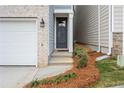 Townhome's front entrance with gray door, brick and siding exterior, and steps leading to the entryway at 702 Smokey Quartz Way, Kennesaw, GA 30144