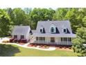 Beautiful home with a welcoming front porch, complete with meticulously landscaped front yard with lots of trees and foliage at 866 Lee Byrd Rd, Loganville, GA 30052