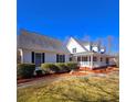 Charming white home with black shutters, a welcoming front porch, and beautifully maintained landscaping at 866 Lee Byrd Rd, Loganville, GA 30052