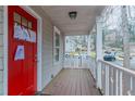 Cozy front porch featuring wood decking and white railings leading to a red front door at 1137 2Nd Nw St, Atlanta, GA 30318
