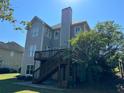 Two-story home with gray siding, deck, and stairs leading to the backyard at 4335 Silent Path, Cumming, GA 30028