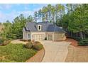 Brick house with a two-car garage, long driveway, and lush landscaping at 201 Russell Ct, Canton, GA 30115