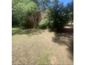 Exterior view of a brick home surrounded by lush trees and greenery, evoking a sense of privacy at 7205 Lakeview Dr, Covington, GA 30014