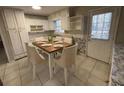 Cozy eat-in kitchen with white cabinets, stainless sink, and dining table set for six at 1600 Whisperwood Trl, Stone Mountain, GA 30088
