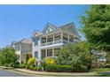 Charming two-story home with double porches, a red front door, and lush landscaping on a sunny day at 7460 Cordery Rd, Cumming, GA 30040