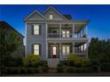 Two-story home with double porches, gray siding, a red door and well-manicured shrubs at 7460 Cordery Rd, Cumming, GA 30040