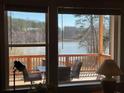 A stunning waterfront view with deck as seen through the living room windows at 4380 Serenity Lake Dr, Cumming, GA 30028