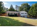Ranch home features brick, white siding, attached garage, and a spacious lawn at 1022 Washington Ave, Woodstock, GA 30188