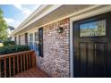 Brick front entrance with a black door, wooden deck, and keyless entry at 1022 Washington Ave, Woodstock, GA 30188