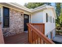 Charming front entrance with a brick facade, wooden deck, and black door at 1022 Washington Ave, Woodstock, GA 30188