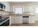 Modern kitchen with stainless steel appliances, granite countertops, and white cabinets at 2104 Barbara Ln, Decatur, GA 30032