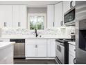 Updated kitchen boasts white cabinets, stainless steel appliances, and stylish backsplash at 1381 Flat Rock Rd, Stockbridge, GA 30281