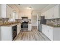 Well-lit kitchen with white cabinets, stainless steel appliances, granite countertops and modern backsplash at 265 N Fayette Ct, Fayetteville, GA 30214