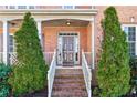 Inviting front entrance with brick steps, decorative pillars, and well-manicured evergreens at 1302 Turtlebrook Ln, Lawrenceville, GA 30043