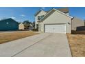 Charming two-story home with a two-car garage and long driveway on a sunny day at 7889 Winkman Dr, Fairburn, GA 30213