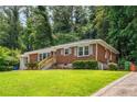 Charming brick home with a well-manicured lawn and gray painted siding at 1893 Windsor Sw Dr, Atlanta, GA 30311