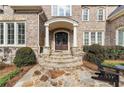 Grand front entrance showcasing stone steps, elegant columns, and a stylish, dark wood double door at 110 Mattison Cv, Atlanta, GA 30319