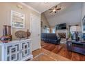 Inviting living room with vaulted ceilings, hardwood floors, and a cozy fireplace at 557 Bradford Park, Loganville, GA 30052