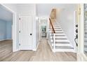 Bright entryway features hardwood floors and a staircase with wood and iron railing at 3524 Pine Grove Drive, Douglasville, GA 30135