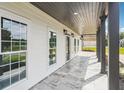 Inviting covered front porch featuring stone flooring, recessed lighting, black columns, and a warm, welcoming ambiance at 4566 Town Manor Dr, Douglasville, GA 30135