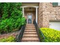 Close up of the charming brick home's front door, front steps, and nicely trimmed front yard at 938 Canterbury Ln, Atlanta, GA 30324