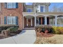 Inviting front porch with brick accents and manicured landscaping at 1683 Wheatstone Dr, Grayson, GA 30017