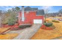 Brick home featuring a side-entry garage, well-maintained landscaping, and long driveway at 1510 Mount Mckinley Dr, Grayson, GA 30017