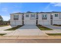 Townhomes with white painted brick, individual garages, gray accents, and a concrete driveway at 305 Heavenly Hollow Pl, Mcdonough, GA 30253