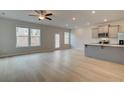 Bright and airy living room featuring large windows, light wood floors, and an open floor plan at 305 Heavenly Hollow Pl, Mcdonough, GA 30253